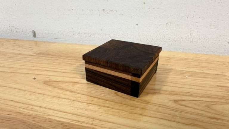 Finished small walnut keepsake box with a beech accent stripe and fitted lid.