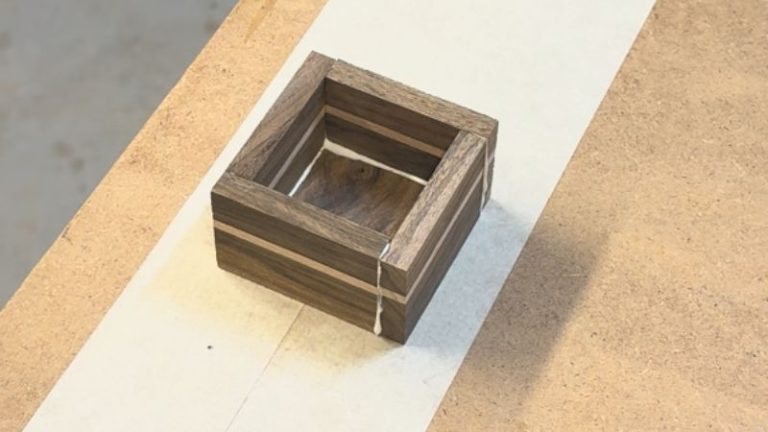 Small walnut and beech keepsake box clamped together during glue-up.
