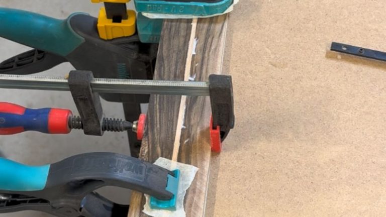 Walnut and beech strips clamped together during the side panel glue-up.