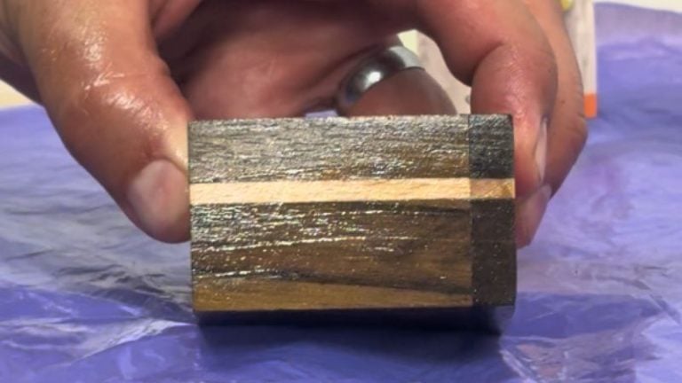 Applying oil to a walnut and beech wooden keepsake box.