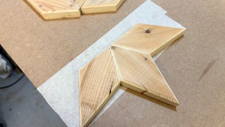 Gluing wooden star pieces together on a flat workbench