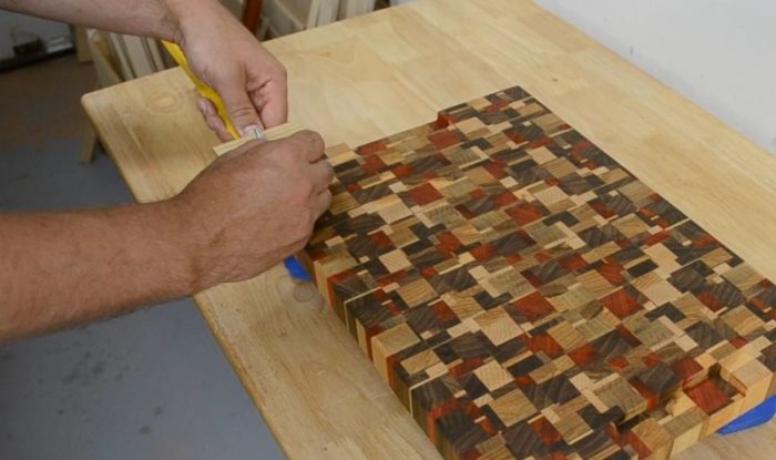 Marking positions for rubber feet on a cutting board with a ruler marking jig